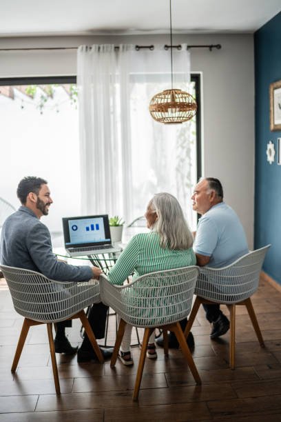 financial advisor having a meeting with senior couple at home